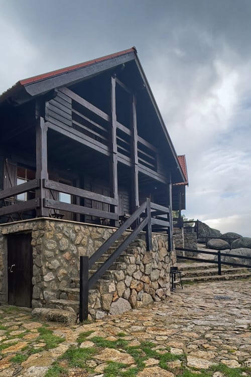 Chalé de pedra e madeira no resort de montanha Cota 1500 em Penhas da Saúde, Portugal com terraço