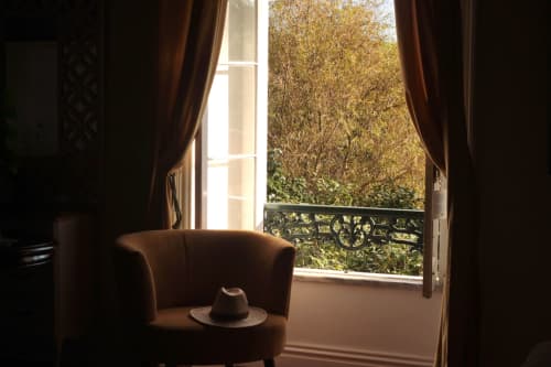 Open French doors at Villa Várzea with autumn trees visible, brown armchair and hat in foreground, Várzea Portugal