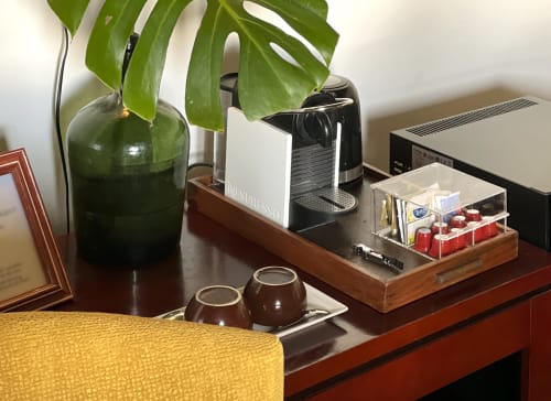Hotel desk at Villa Várzea with Nespresso machine, plant, coffee capsules, and amenities