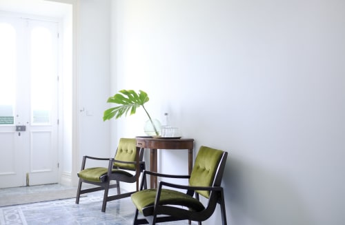 Modern lobby at Villa Várzea guesthouse in Várzea with lime green chairs, wooden table, Monstera plant, and minimalist white