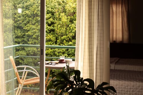 Balcony at Villa Várzea with views of lush greenery, reading nook with small table and books overlooking forest