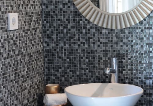 Modern bathroom at Villa Várzea with black mosaic tile walls, white vessel sink, and decorative mirror in Várzea, Portugal