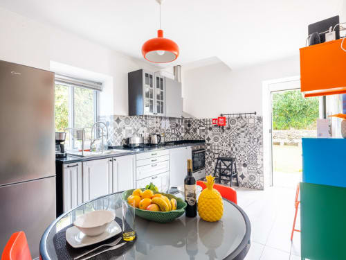 Modern kitchen at Villa Várzea with round dining table, colorful décor, and patterned backsplash in Várzea