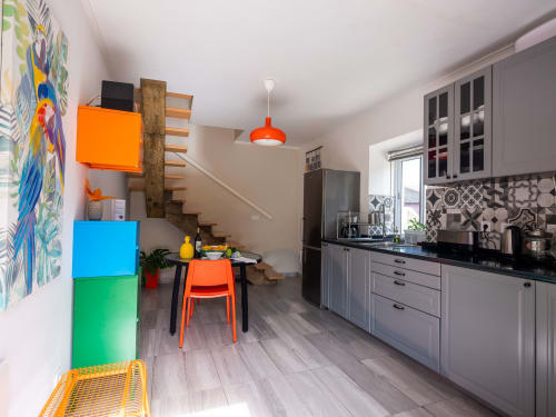 Modern kitchen and dining area at Villa Várzea guesthouse in Várzea with colorful decor and wooden stairs