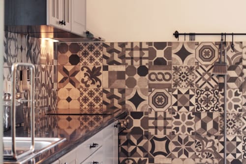 Modern kitchen at Villa Várzea with patterned tile backsplash, white cabinets, and stainless steel fixtures in Várzea,
