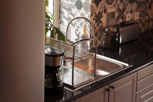 Villa Várzea kitchen sink with stainless steel countertop, copper faucet, and decorative plant in Portuguese accommodation