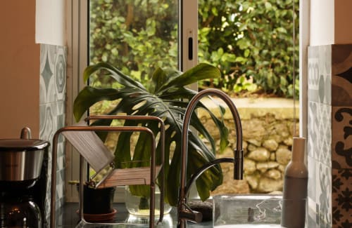 Modern kitchen sink at Villa Várzea B&B in Várzea, Portugal, with plant and garden views through open doors