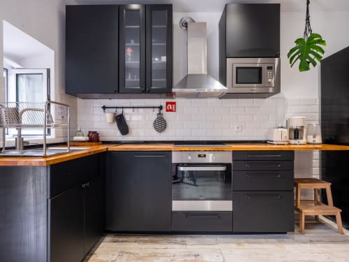 Modern black kitchen with wooden countertops at Villa Várzea boutique hotel in Várzea, Portugal