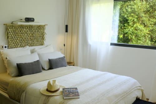 Bright bedroom at Villa Várzea B&B with cream bedding, woven headboard, and garden views from Várzea, Portugal