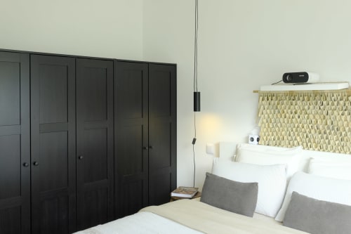 Modern bedroom at Villa Várzea in Várzea with black wardrobe, woven headboard, and pendant lighting.