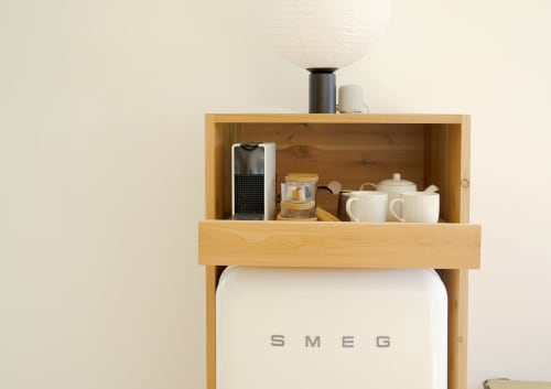 Wooden wall unit with storage shelves displaying coffee maker, tea set, and kitchen accessories at Villa Várzea guesthouse in