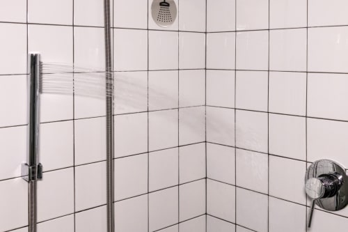 Modern bathroom shower at Casa Mirko B&B in Arezzo with white subway tiles, rainfall showerhead, and handheld shower