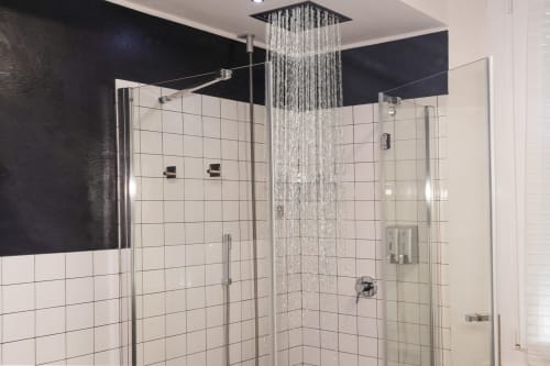 Modern bathroom at Casa Mirko in Arezzo with rainfall showerhead, glass enclosure, and white subway tile