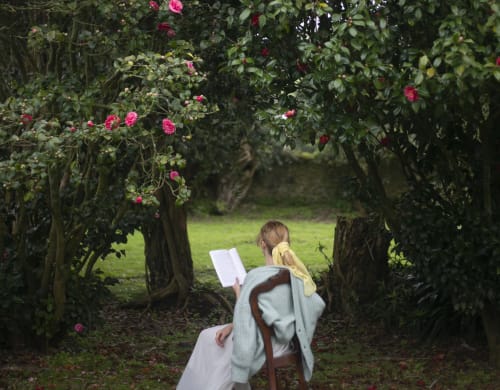 Person reading in rose garden tunnel at Villa Várzea, a charming Portuguese bed and breakfast retreat.