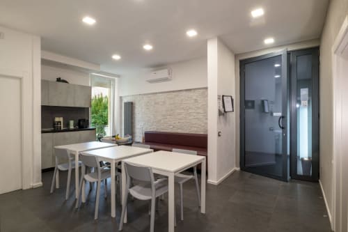 Modern Casa Mirko BnB dining area in Arezzo with white tables, kitchen, and terrace access