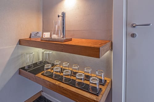 Casa Mirko hospitality shelf with glassware, water dispenser, and amenities in Arezzo