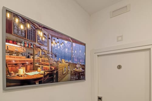 Framed artwork of a cozy Italian coffee shop interior displayed in Casa Mirko, Arezzo