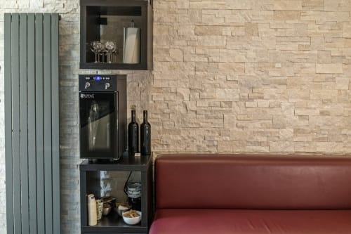 Casa Mirko bar setup in Arezzo with wine cooler, glasses, bottles, and burgundy seating