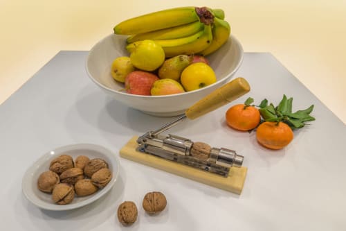 Fresh fruit, nuts, and vintage nutcracker on white surface at Casa Mirko B&B in Arezzo