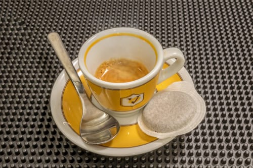 Yellow espresso cup with saucer, spoon, and tea bag at Casa Mirko bed and breakfast in Arezzo