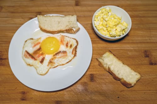 Breakfast plate at Casa Mirko B&B Arezzo: fried egg with bacon, toast, and corn side dish
