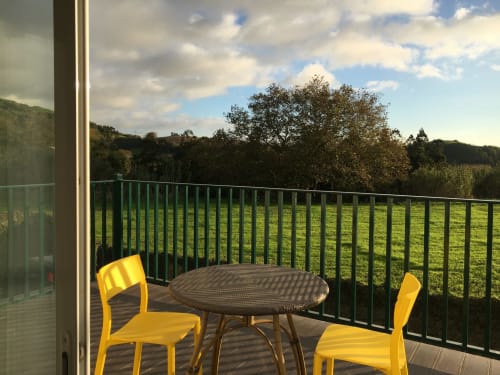 Deck at Villa Várzea B&B in Várzea, Portugal with yellow chairs, round table, and countryside views