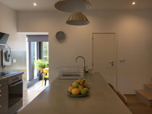 Modern kitchen at Villa Várzea B&B in Várzea with island counter, fruit bowl, and garden view through glass doors