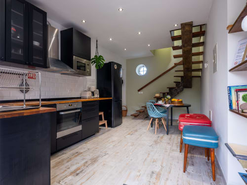 Modern kitchen and dining area in Hiker Nest at Villa Várzea, Várzea with black cabinets, wooden floors, and mountain view