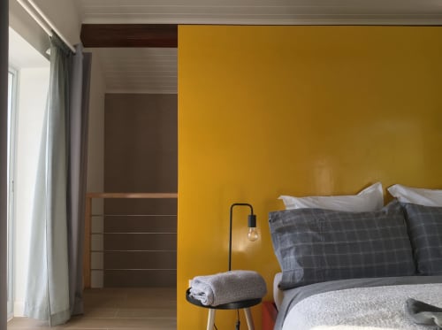 Modern bedroom at Villa Várzea with bold yellow accent wall, gray bedding, wood details, and mountain views in Várzea