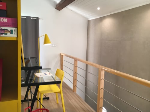 Modern design studio at Villa Várzea with yellow chair, desk, and mountain view balcony railing
