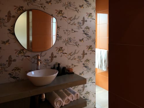 Modern bathroom vanity with round mirror at Villa Várzea Design Nest, featuring vessel sink and botanical wallpaper