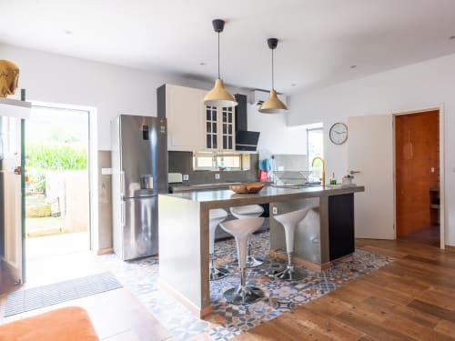 Modern kitchen with island seating at Villa Várzea Design Nest in Várzea, Portugal, featuring stainless steel appliances and