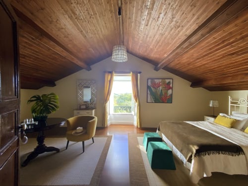 Charming Suite at Villa Várzea with vaulted wood ceiling, mountain view, sitting area, and bed with yellow pillows