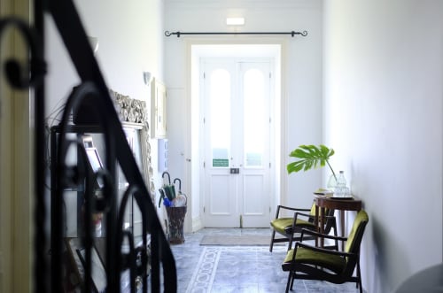 Bright hallway at Villa Várzea with white doors, green chair, plant, and sitting area in Portuguese countryside