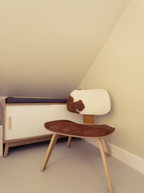 Mobilier années 50 dans la chambre Jane de La Guirtelle B&B, Lainsecq avec bureau en bois et fauteuil imprimé vache