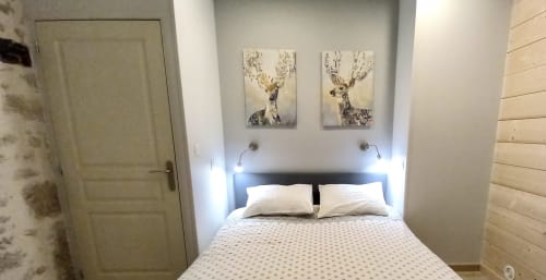 Chambre moderne à la villa La Maison De Fleurat à Domeyrot avec lit, œuvre de cerf et éclairage ambiant