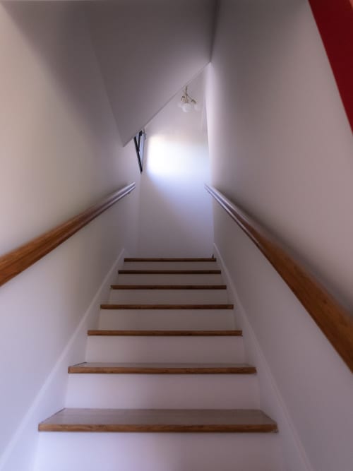 Escalier avec marches en bois et rampes à La Guirtelle B&B, Lainsecq, menant vers la lumière naturelle