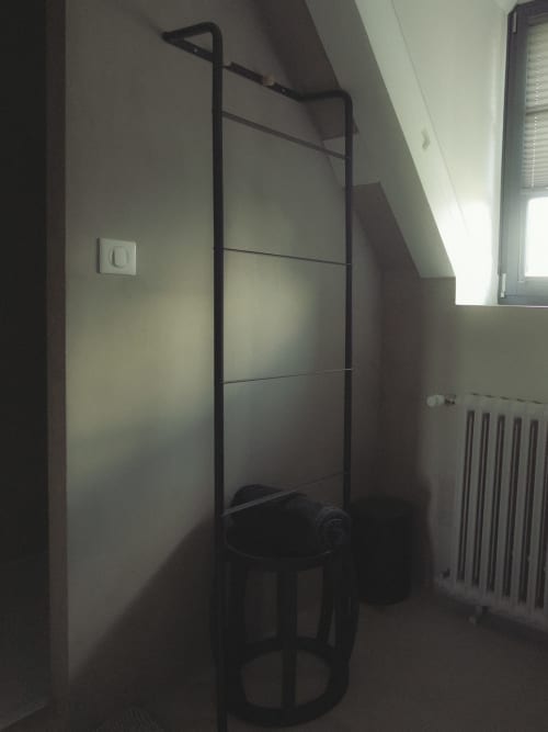 Chambre minimaliste à La Guirtelle à Lainsecq avec portant métallique noir et radiateur
