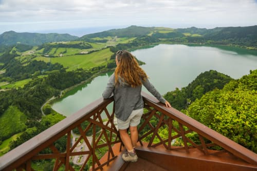 Woman overlooking Várzea lakes and green valleys from scenic viewpoint at Villa Várzea