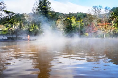 Person enjoying geothermal hot pool at Villa Várzea in Várzea, Portugal, surrounded by lush forest and steam