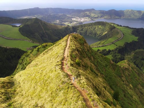 Hiking trail on green mountain ridge overlooking lakes and valleys near Villa Várzea in Açores, Portugal