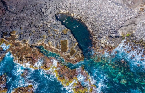Aerial view of rocky coastal cliffs and turquoise waters at Villa Várzea in Várzea, Portugal