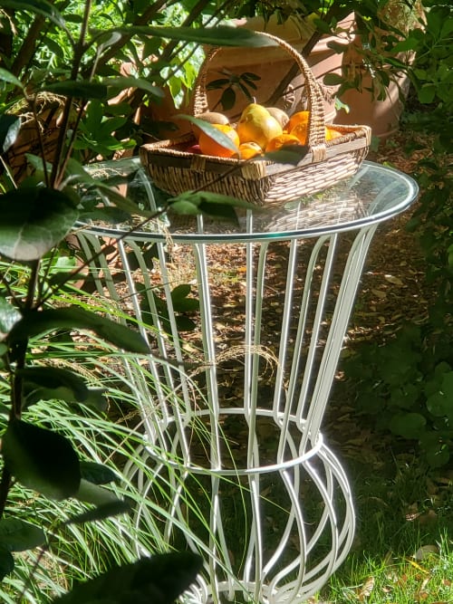 Panier en osier avec fruits frais sur table en verre, entouré d'un jardin luxuriant à Logis des Tourelles, Cognac