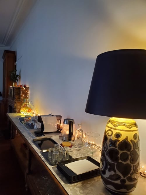 Table de nuit élégante au Logis des Tourelles avec lampes décoratives, verres et ambiance lumineuse chaleureuse à Cognac