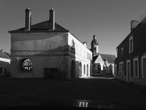 Historic stone buildings with chimneys in Lainsecq village square, La Guirtelle BnB exterior