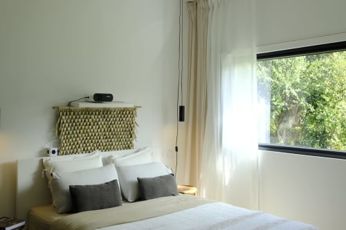 Modern bedroom at Villa Várzea with garden view, white bedding, woven headboard, and natural light from large windows