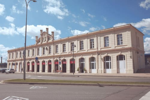 Fachada del hotel Estació del Nord en Vic, Barcelona - edificio histórico beige con puertas rojas y ventanas arqueadas