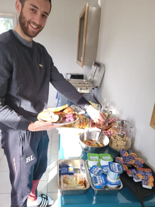 Homme souriant présentant un petit-déjeuner à l'Hôtel Cheverny La Vie Est Belle, Cheverny, France