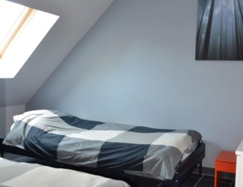 Chambre contemporaine sous les combles à l'hôtel Mape de Dampierre-en-Burly avec puits de lumière et literie rayée