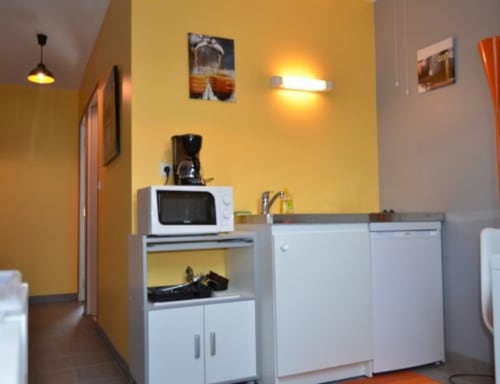 Cuisine moderne de l'Hôtel Mape à Dampierre en Burly avec murs jaunes, électroménagers blancs et luminaires suspendus